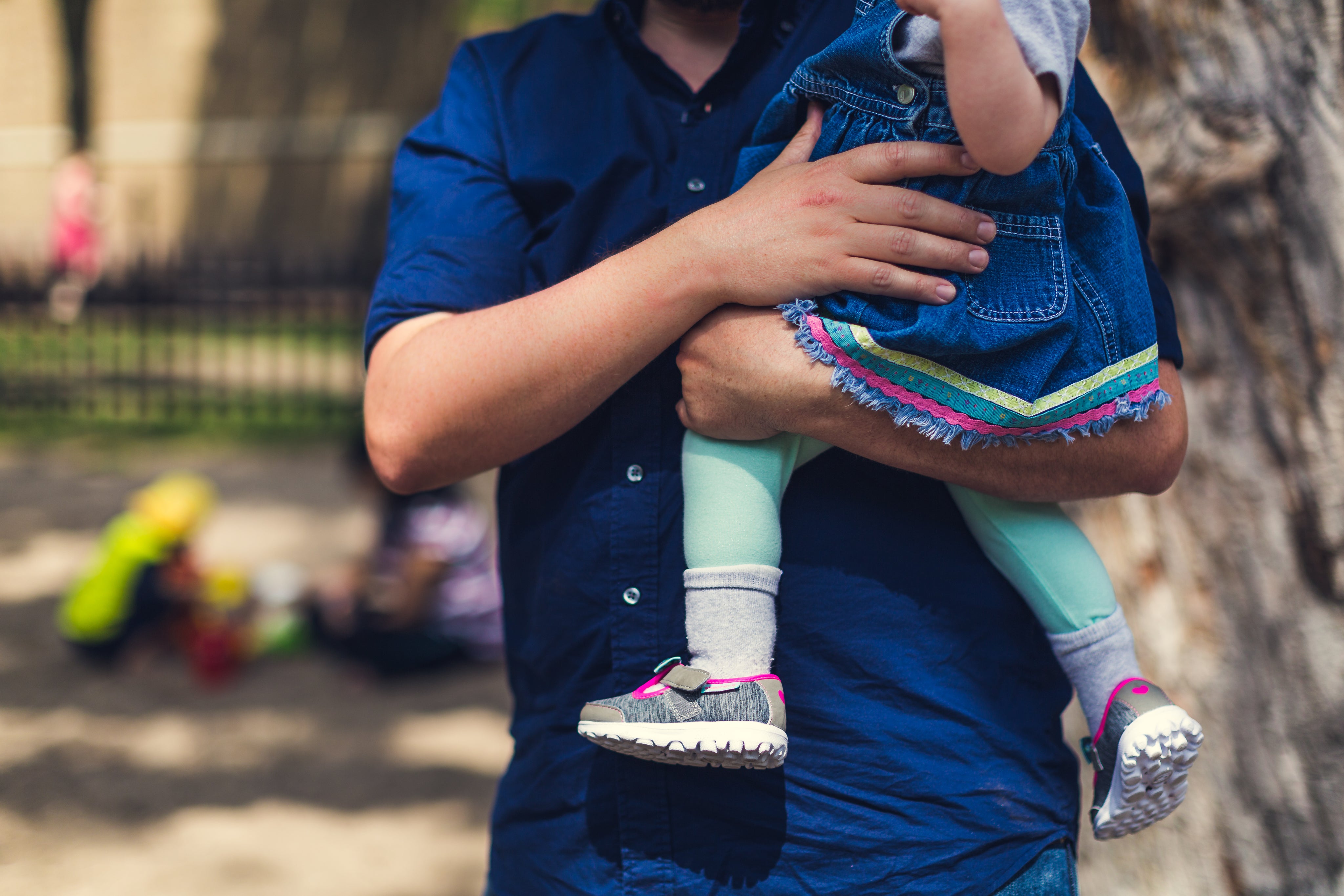 father carrying a young child in his arms